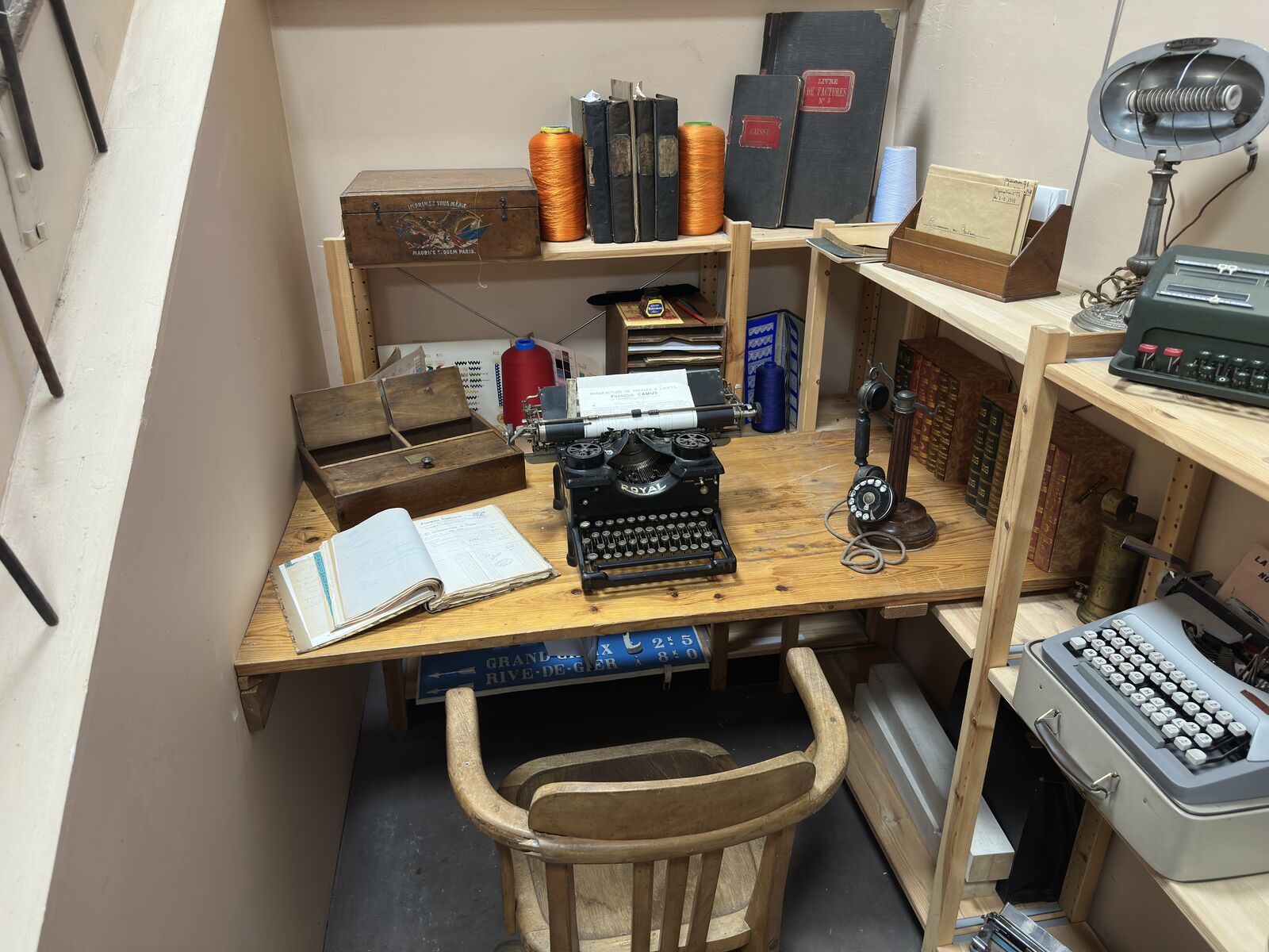 Bureau d’usine reconstitué : machines à écrire, registres et étagères en bois